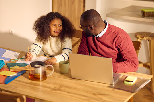 Father helps his daughter with homework