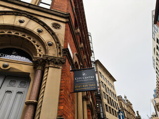 Naklejka premium City Centre Manchester dental and implant clinic sign on historic brick building in urban street