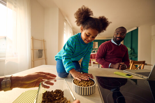 Little girl prepares food for her pet