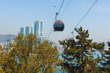 Busan Air Cruise, Busan cable car, ride on multicoloured sky capsule gondola route, with Songdo beach and Skywalk and Busan Bay panorama, South Korea, Songdo Station in a spring sunny day © tsuguliev