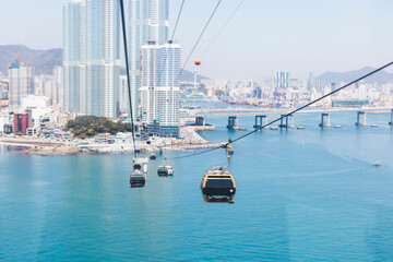 Busan Air Cruise, Busan cable car, ride on multicoloured sky capsule gondola route, with Songdo beach and Skywalk and Busan Bay panorama, South Korea, Songdo Station in a spring sunny day © tsuguliev