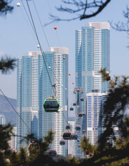 Busan Air Cruise, Busan cable car, ride on multicoloured sky capsule gondola route, with Songdo beach and Skywalk and Busan Bay panorama, South Korea, Songdo Station in a spring sunny day © tsuguliev