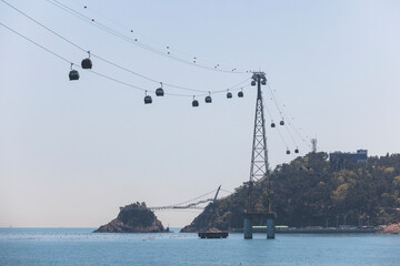 Busan Air Cruise, Busan cable car, ride on multicoloured sky capsule gondola route, with Songdo beach and Skywalk and Busan Bay panorama, South Korea, Songdo Station in a spring sunny day © tsuguliev