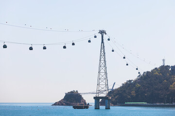 Busan Air Cruise, Busan cable car, ride on multicoloured sky capsule gondola route, with Songdo beach and Skywalk and Busan Bay panorama, South Korea, Songdo Station in a spring sunny day © tsuguliev
