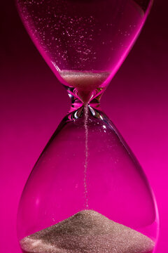 Hourglass on a bright pink background
