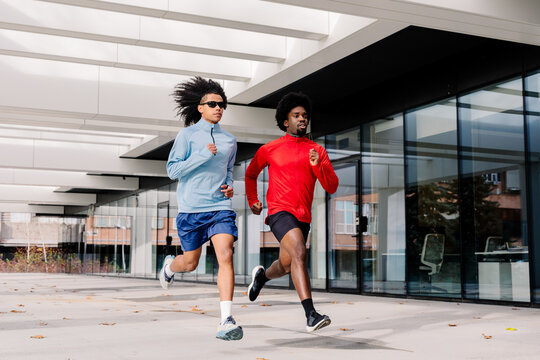 A city fitness scene showing runners jogging through modern streets 
