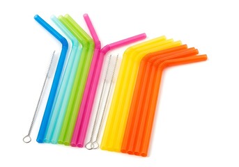 Colorful reusable drinking straws with cleaning brushes on white