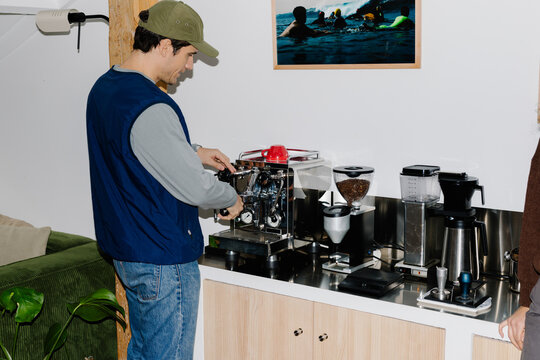 A self-employed creative using an espresso machine to prepare coffee