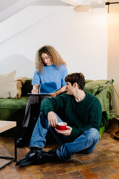 Self-employed adults in a living room, collaborating on remote tasks