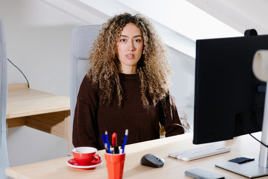 Medium shot of a woman at a home workspace looking at camera