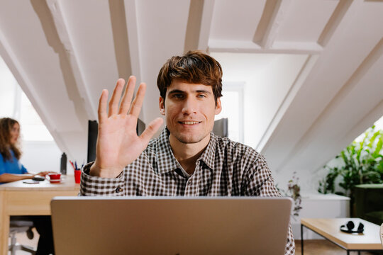 Entrepreneur waving at the camera with a positive attitude