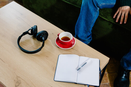 Coffee table in a living room with headphones and an open notebook