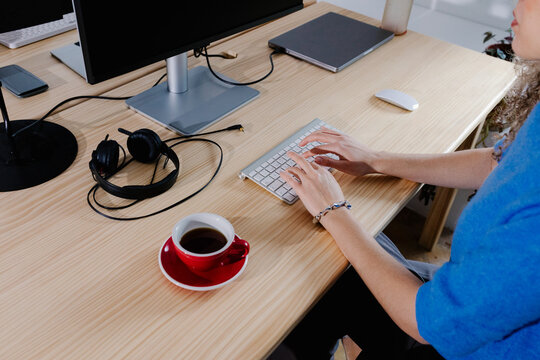 Close-up of the desk of an anonymous female entrepreneur as she types