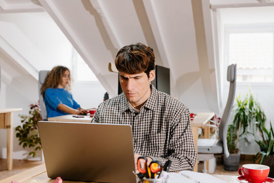 Mid-range view of a home office with two freelancers at separate desks