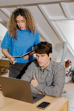 Professionals review the details of a remote work project on a laptop