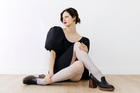 Woman in black dress and white tights