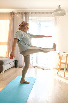 Senior Woman Practicing Single-Leg Balance Yoga at Home