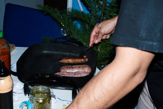 Cooking Sausages on a Stovetop at Home During Winter Season