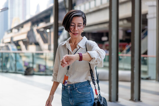 Woman checking the time on her smartwatch in the city