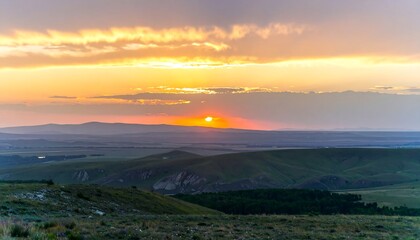 Obraz premium Sunset over rolling hills and landscape.