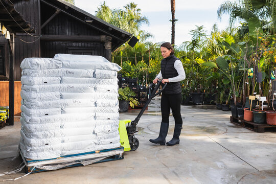 Worker moving pallet of soil