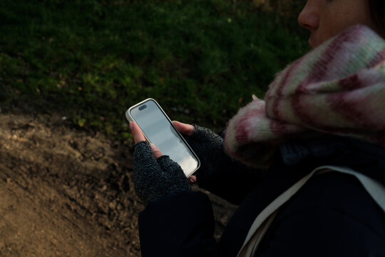 Woman Holding Phone on Forest Path