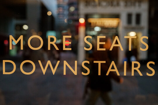Glass Sign Saying "More Seats Downstairs"