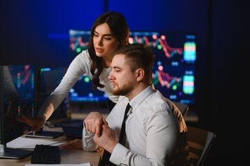 Financial brokers analyzing stock market data on computer screens