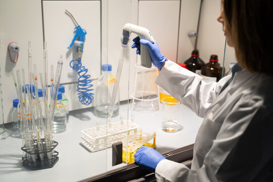Scientist Using Pipette in Chamber