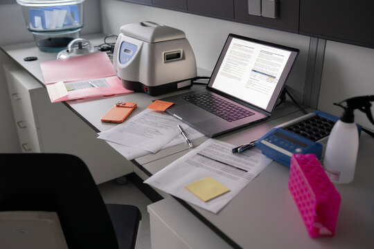 Laboratory Workspace With Equipment and Paperwork on Desk
