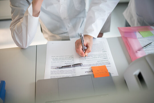 Researchers Writing Notes During a Study in a Lab Setting