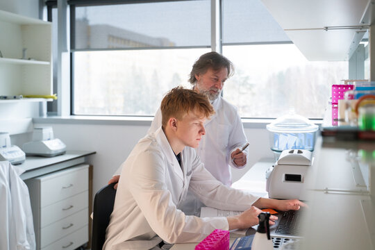 Young Scientist Works on Computer With Mentor in a Lab Setting