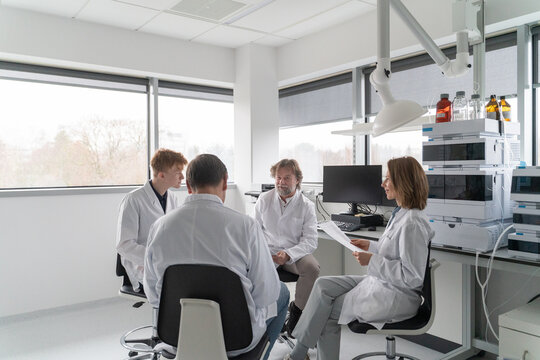 Group of Scientists Discussing Research in Laboratory Setting