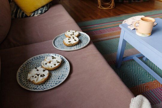Sliced Bagel With Toppings and Coffee on a Blue Table