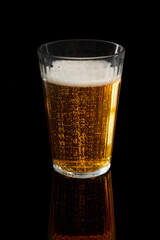 Glass of refreshing beer creating bubbles and foam