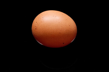 Brown chicken egg representing healthy eating on black