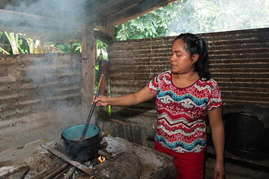 Stirring a Pot Over Open Flame in Kitchen
