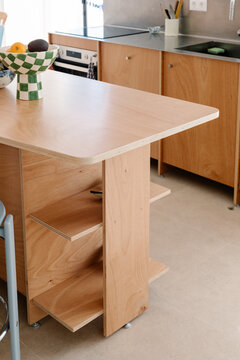 A compact wooden kitchen island in a modern minimalist apartment