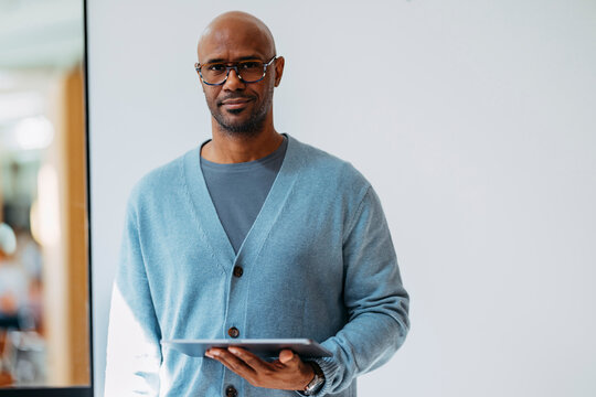 Businessman With Glasses Holding Tablet In Office