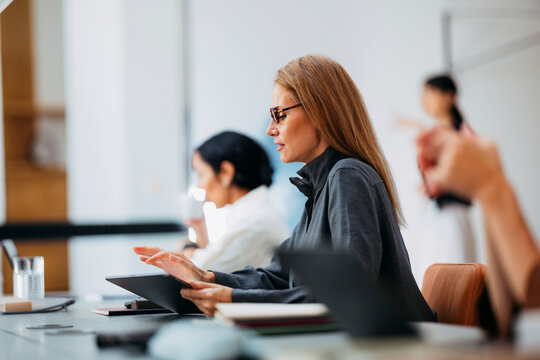 Businesswoman in Meeting with Tablet in Office