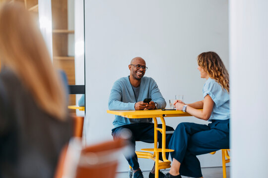 Friendly Business Meeting At Bright Yellow Table