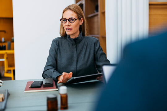 Businesswoman Discussing Documents In Office