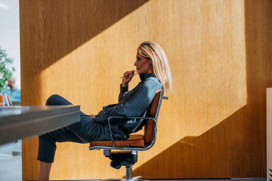 Professional Woman Relaxing In Modern Office Chair