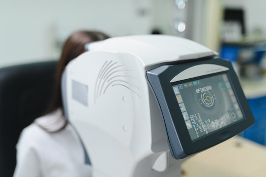 Patient undergoing eye exam using autorefractor machine