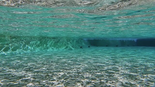 Underwater view of thrown coins in the water and popular sculpture at Trevi fountain a popular landmark in Rome. Tourists throw coins as tradition, slow motion