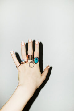 Person wearing many different fashion style jewellery rings with flash