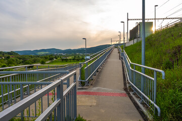 Obraz premium A concrete walkway creating barrier-free access to a small railway station.