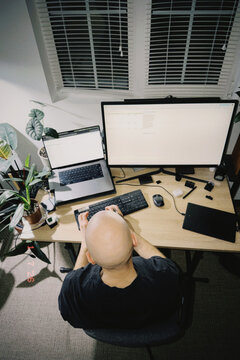 Man working on multi-screen home office setup