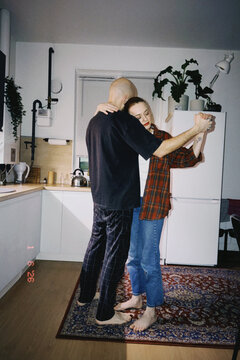 Young couple dancing intimately in kitchen during romantic moment