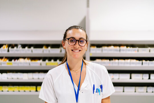 Female pharmacist smiling in hospital pharmacy department